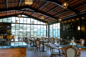 a dining room with tables and chairs and windows at Hotel Casa Xaa in Tlatlauquitepec