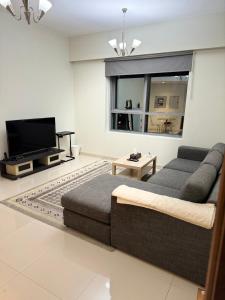 een woonkamer met een bed en een flatscreen-tv bij 1 BHK in Al Khan Sharjah in Sharjah