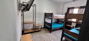 a room with three bunk beds and a flat screen tv at VOY Hostales - 4 Norte in Viña del Mar