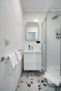 ein weißes Badezimmer mit einem Waschbecken und einem Spiegel in der Unterkunft Blick Apartments - Riverside Mini Apartment in Zgorzelec