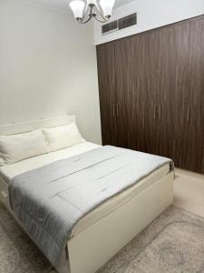 a bedroom with a bed and a brown cabinet at 1 BHK in Al Khan Sharjah in Sharjah