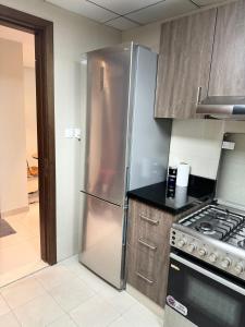 a kitchen with a stainless steel refrigerator and a stove at 1 BHK in Al Khan Sharjah in Sharjah