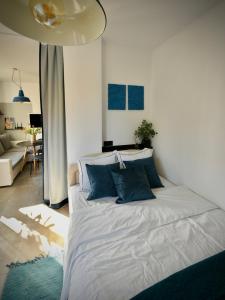 a bedroom with a large white bed with blue pillows at Cozy apartment Sunny Beach in Sunny Beach