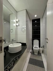 a bathroom with a sink and a toilet and a mirror at Damac Tower Jeddah apartment in Jeddah