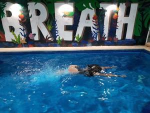 a woman is swimming in a swimming pool at Santa Fe Studios And Suites in Cancún