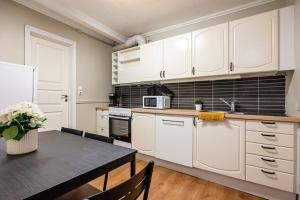 a kitchen with white cabinets and a dining room table at Kong Oscars gate 28 - 303 in Bergen +40 photos