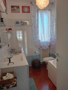 a bathroom with a sink and a toilet and a window at La birichina in Santarcangelo di Romagna