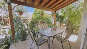 een tafel en stoelen op een patio met planten bij STAY Cactus House in Voroklini