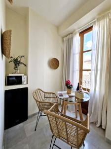 una sala da pranzo con tavolo, sedie e finestra di Apartamentos VITA CENTER a Granada