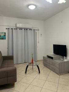 ein Wohnzimmer mit einem Sofa und einem TV in der Unterkunft APPART 2 BEDROOMS 500M TO BEACH in Flic-en-Flac