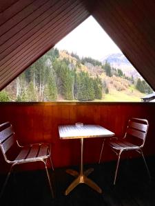 einen Tisch und zwei Stühle in einem Zimmer mit Fenster in der Unterkunft Al_titude1138 in Les Contamines-Montjoie