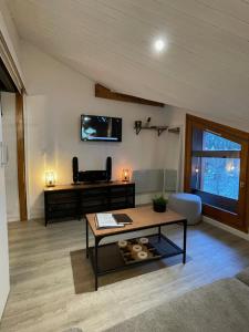 ein Wohnzimmer mit einem Tisch und einem TV an der Wand in der Unterkunft Al_titude1138 in Les Contamines-Montjoie