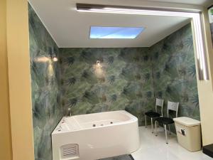 a bathroom with a tub and a green wall at Hermosa suite 2 cerca de todo in Guayaquil