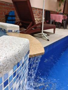 a swimming pool with a blue and white tiles on the side at HBCF Hotel Boutique Casa Farallones de Santiago de Cali in Cali