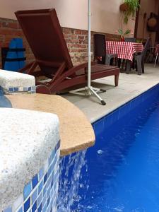 a blue swimming pool with a table and an umbrella at HBCF Hotel Boutique Casa Farallones de Santiago de Cali in Cali