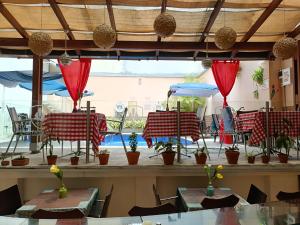 a restaurant with tables and chairs and red drapes at HBCF Hotel Boutique Casa Farallones de Santiago de Cali in Cali