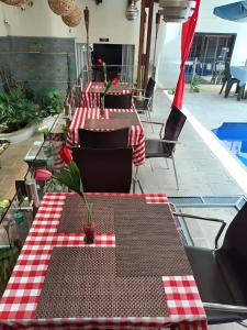 a row of tables and chairs with red and white checkered table cloth at HBCF Hotel Boutique Casa Farallones de Santiago de Cali in Cali