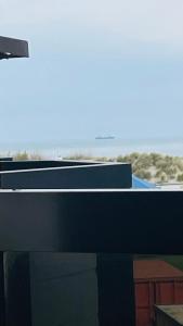 a black desk with a view of the ocean at Studio Sia - Lichtrijke studio met balkon met zijzeezicht in hartje de Panne in De Panne