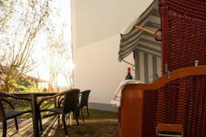 a patio with chairs and a table and an umbrella at FeWo Konstanze in Borkum
