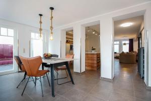 a dining room and living room with a table and chairs at FeWo Konstanze in Borkum