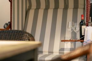 a couch with two wine glasses and wine bottles at FeWo Konstanze in Borkum +13 photos