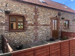 a brick house with a wooden door and windows at Stunning remote norfolk apartment in Mileham