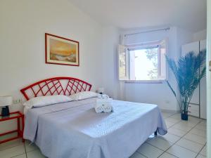 una camera da letto con un letto con una coperta bianca e una finestra di Dommos - Pintada Apartments a Cala Liberotto