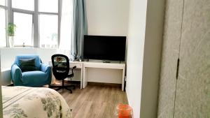 - une chambre avec un bureau, une télévision et une chaise dans l'établissement Ms. Zhang's Flat 303, à Abu Dhabi
