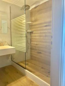 a bathroom with a glass shower and a sink at Ocean Sun 4 in Fira