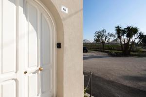 una puerta blanca a un edificio con aparcamiento en Cientopera Suite Rooms, en Pontecagnano Faiano