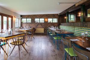 uma sala de jantar com mesas e cadeiras de madeira em Dartmoor Halfway Campsite em Newton Abbot
