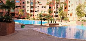 a large swimming pool in the middle of a building at ☆HIVERNAGE☆ Charming , Spacious & Bright with Pool in Marrakech