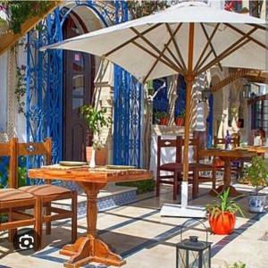 una mesa con sombrilla en el patio en Maison à hergla, en Sousse