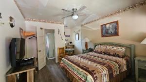 1 dormitorio con 1 cama y TV de pantalla plana en Sequoia Lodge, en Kernville