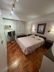 a bedroom with a bed and a television in it at Departamento temporal 2 ambientes in Buenos Aires