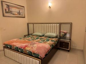 - une petite chambre avec un lit et un miroir dans l'établissement Holidazzle Villa, à Karachi