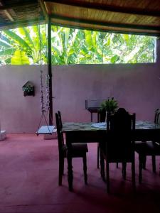 einen Tisch und Stühle in einem Zimmer mit einem großen Fenster in der Unterkunft 7 camas de casal - Casa próxima ao Bumbódromo in Parintins