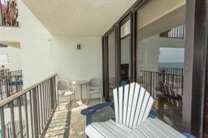 balcón con silla blanca, mesa y sillas en ROYAL GARDEN RESORT 1012 condo, en Myrtle Beach