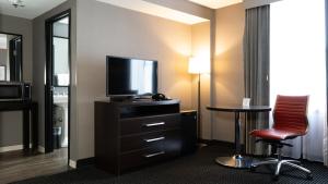 a hotel room with a television and a chair and a table at Roomza Inner Harbor at Lord Baltimore in Baltimore