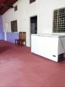ein weißes Zimmer mit 2 Stühlen und einem Tisch in der Unterkunft 7 camas de casal - Casa próxima ao Bumbódromo in Parintins