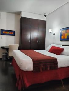 a bedroom with a large bed with a red pillow at HBCF Hotel Boutique Casa Farallones de Santiago de Cali in Cali