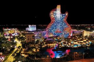 a city at night with a guitar shaped building at Near Beach/kayaks/HtdPool/Tiki/BBQ/Gameroom in Pompano Beach