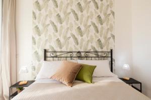 1 dormitorio con 1 cama y papel pintado con motivos florales en Cientopera Suite Rooms, en Pontecagnano Faiano