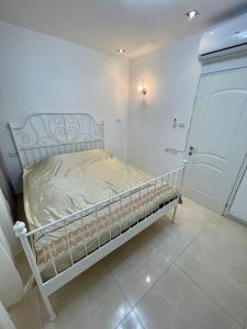 Cama blanca en habitación blanca con puerta en Bat Yam Penthouse Sea View, en Bat Yam