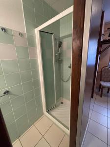 ein Bad mit einer Dusche und einer Glastür in der Unterkunft Hôtel Elaïa in Corps