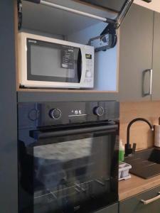 um micro-ondas sentado em cima de um fogão numa cozinha em Apartments Blažič em Kranjska Gora