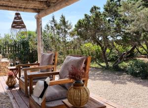 a porch with two chairs and a vase at Formentera Mind Yoga & Fit in Playa Migjorn