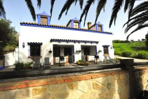 una casa blanca con un muro de piedra en Finca La Cantarera, en Tarifa
