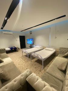 a room with three beds and a flat screen tv at رتز السويدي in Riyadh