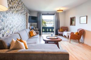 a living room with a couch and a table at Aktivhotel Föttinger in Steinbach am Attersee